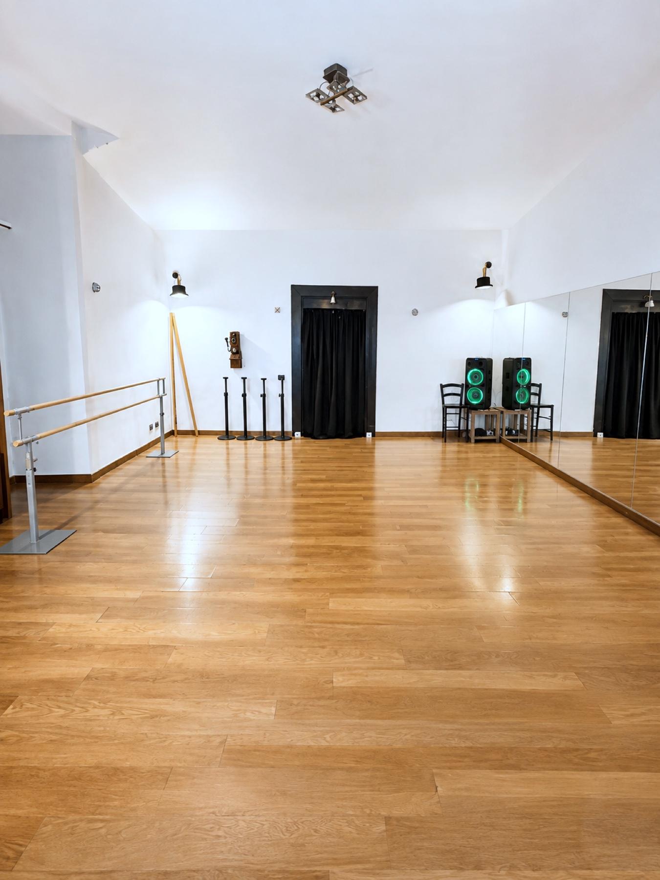 La sala di Be Different: pista in parquet, specchi e luci colorate viola e verdi